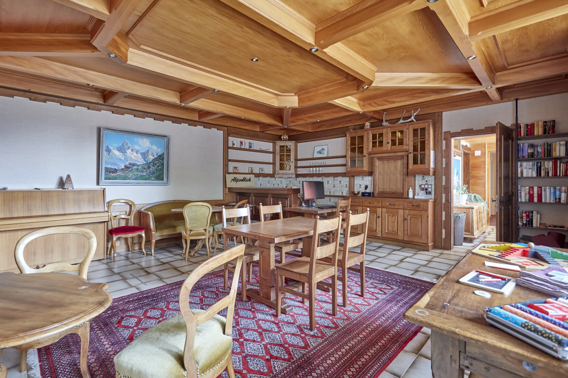 Salon Catherine avec plafond à caissons, bibliothèque, piano et tapis persan