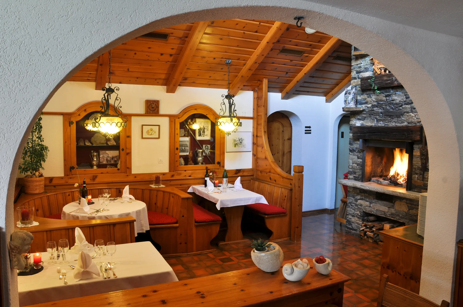 Restaurant-Stübli avec cheminée, boiseries et tables élégamment dressées
